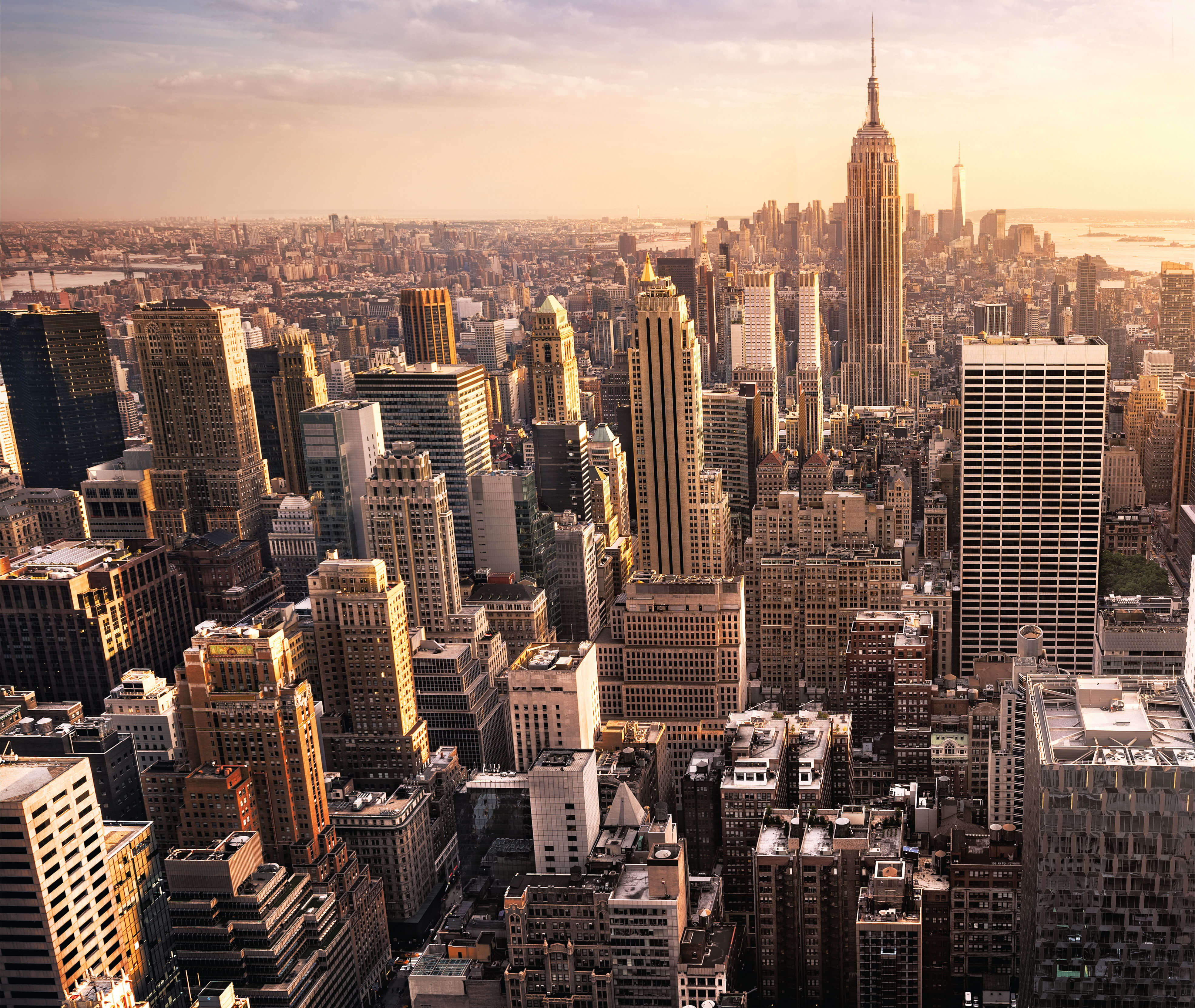 An aerial view of the city of New York showcasing its towering buildings and the wind gracefully flowing through.