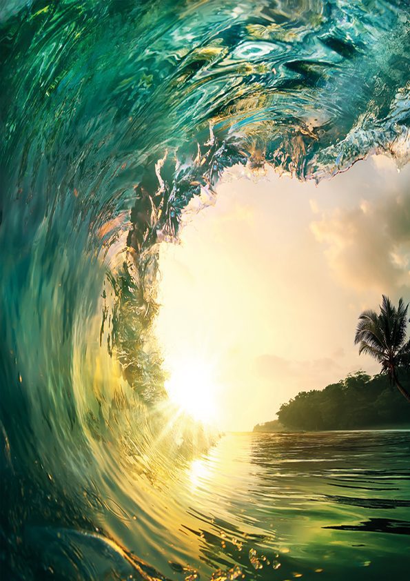 A wave crashing against the shore during a breathtaking sunset.